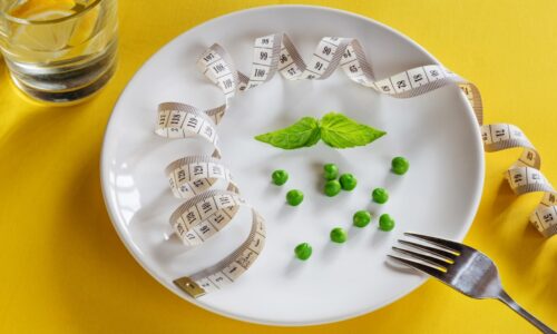 A white plate topped with peas and measuring tape