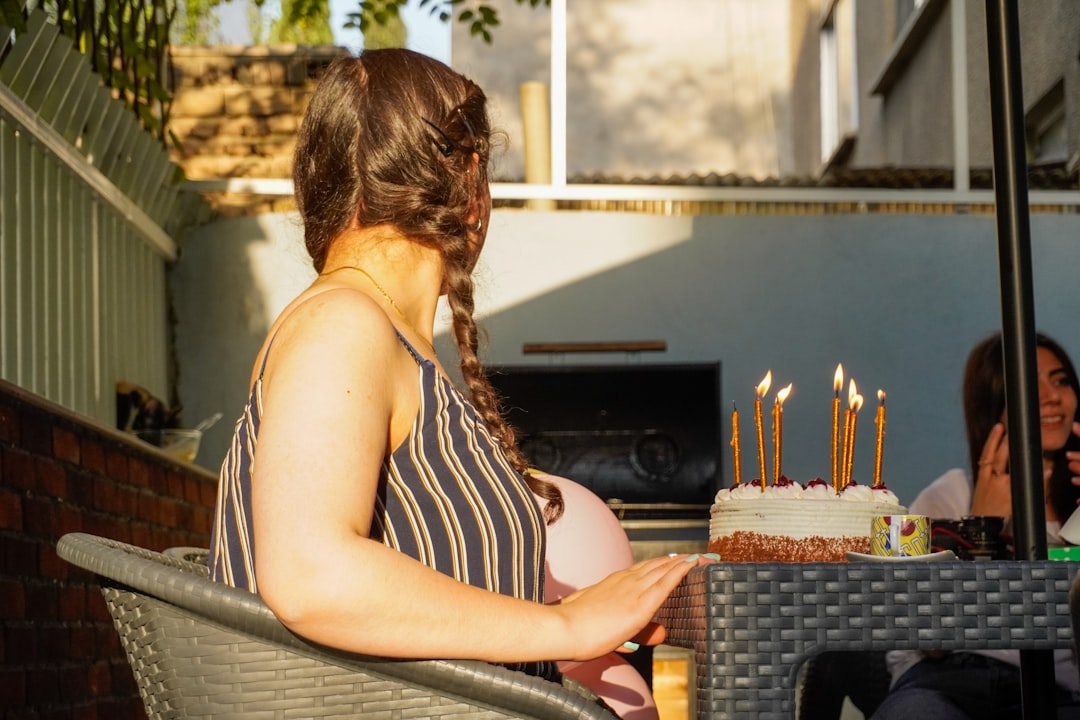 A woman sits at a birthday table.