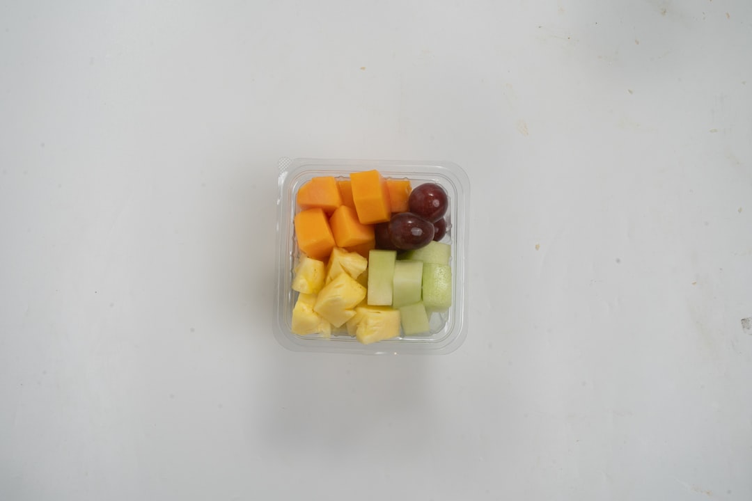 A plastic container filled with cut up fruit