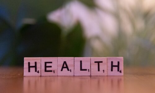 A wooden block spelling the word health on a table