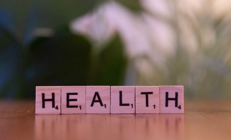 A wooden block spelling the word health on a table