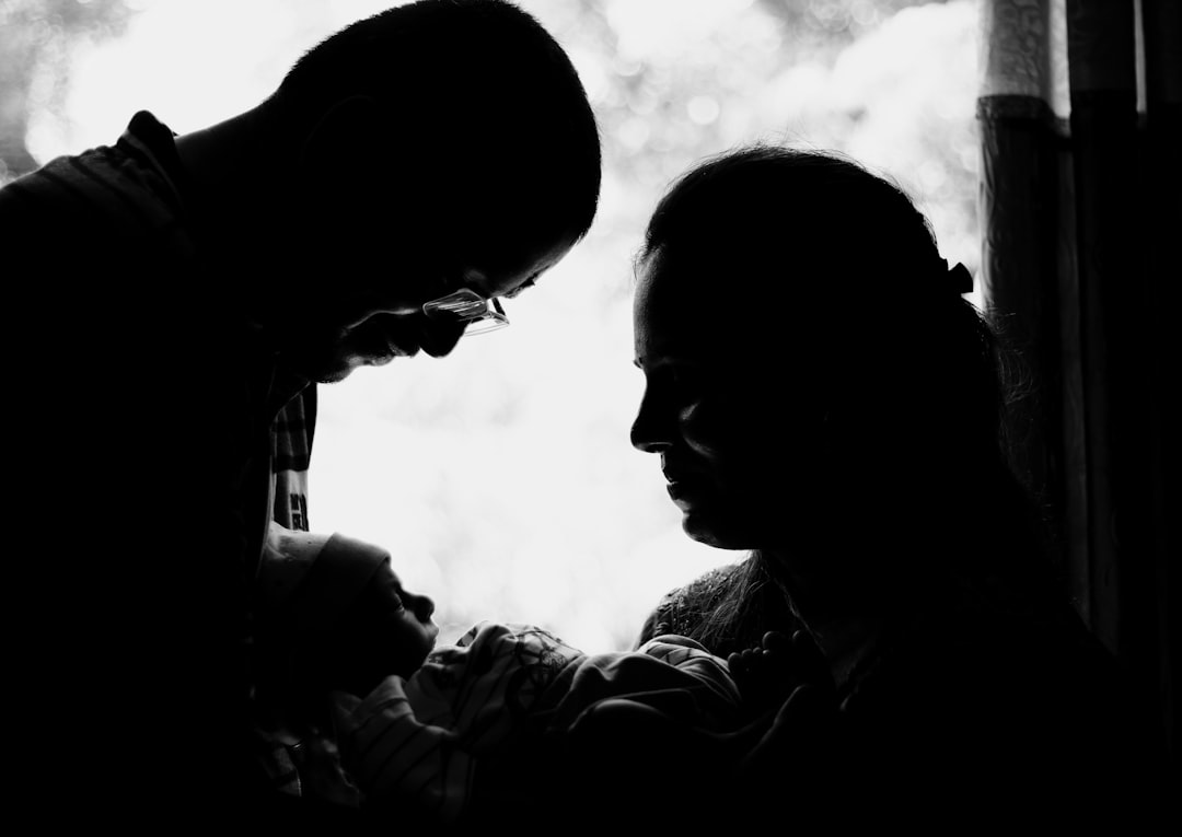 A black and white photo of two people looking at a cell phone