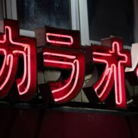 a red neon sign with asian writing on it