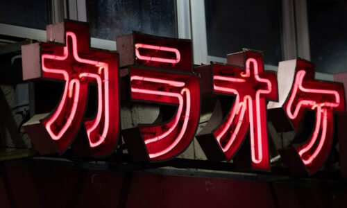 a red neon sign with asian writing on it