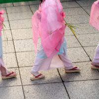 A group of young girls walking down a sidewalk