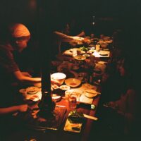 a group of people sitting at a table with plates of food