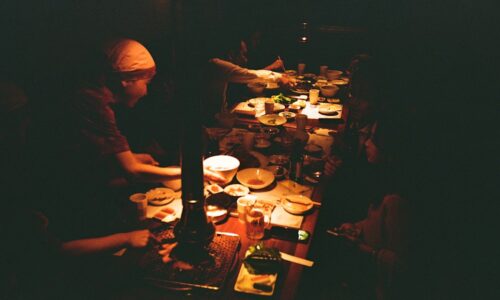 a group of people sitting at a table with plates of food