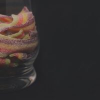 a glass filled with candy sitting on top of a table