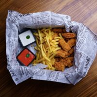 A paper bag filled with food on top of a wooden floor