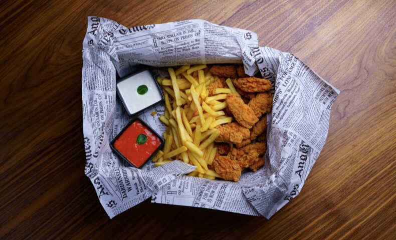 A paper bag filled with food on top of a wooden floor