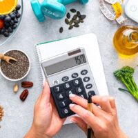 食材と電卓でカロリー管理をしている産後ダイエット中の女性の手元