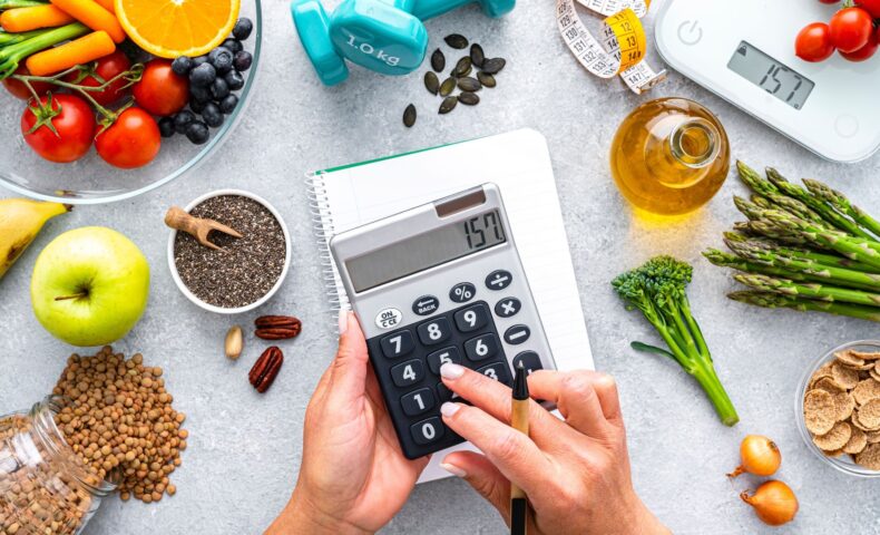 食材と電卓でカロリー管理をしている産後ダイエット中の女性の手元