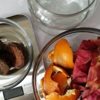 酵素ドリンクの材料（黒糖、オレンジの皮、ドラゴンフルーツの皮、ガラス瓶）