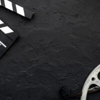 映画フィルムとカチンコが置かれた黒い背景｜動画で学べる産後エクササイズのイメージ