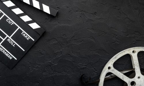 映画フィルムとカチンコが置かれた黒い背景｜動画で学べる産後エクササイズのイメージ