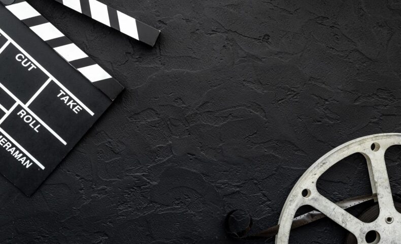 映画フィルムとカチンコが置かれた黒い背景｜動画で学べる産後エクササイズのイメージ