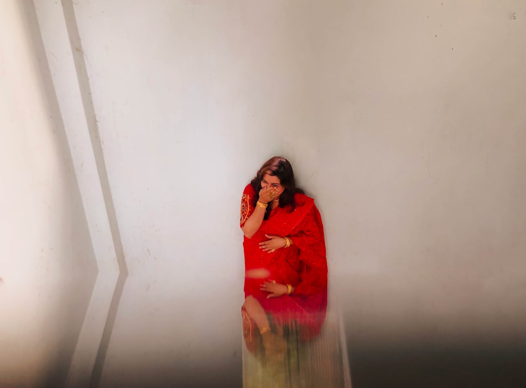 A woman in a red dress talking on a cell phone