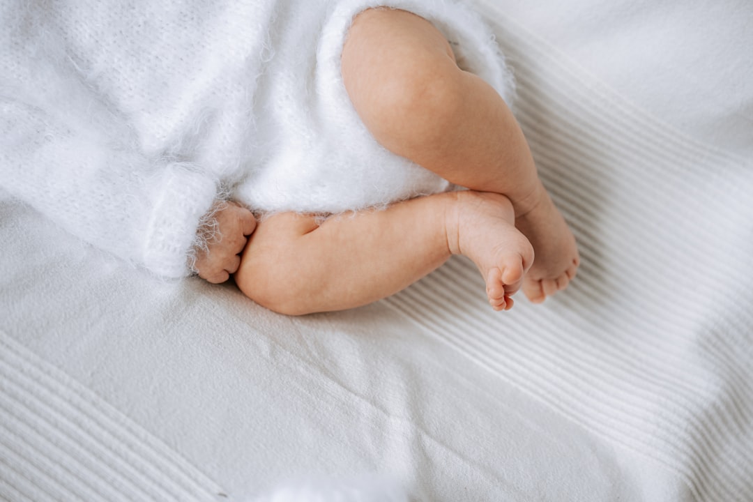 Tiny baby feet resting on a bed.