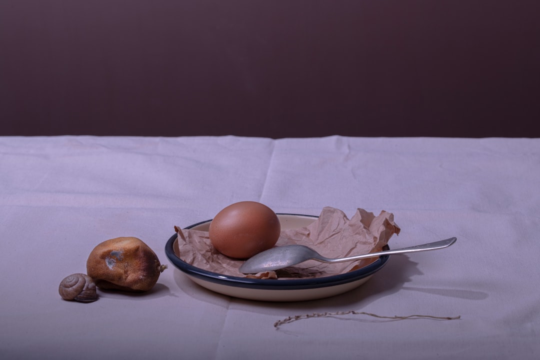a bowl of eggs and a spoon on a table