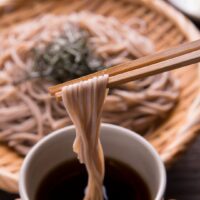 十割そばをつゆにつけて食べる様子｜産後ダイエットに効果的な低GI食品