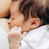 母乳育児中の赤ちゃんと母親が寄り添う安心感のある授乳シーン