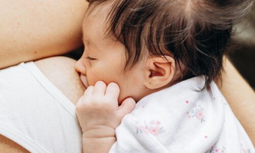 母乳育児中の赤ちゃんと母親が寄り添う安心感のある授乳シーン